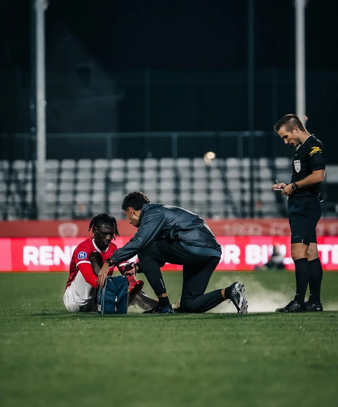 Yoann Baldo kinésithérapeute prodiguant des soins à un joueur professionnel sur le terrain